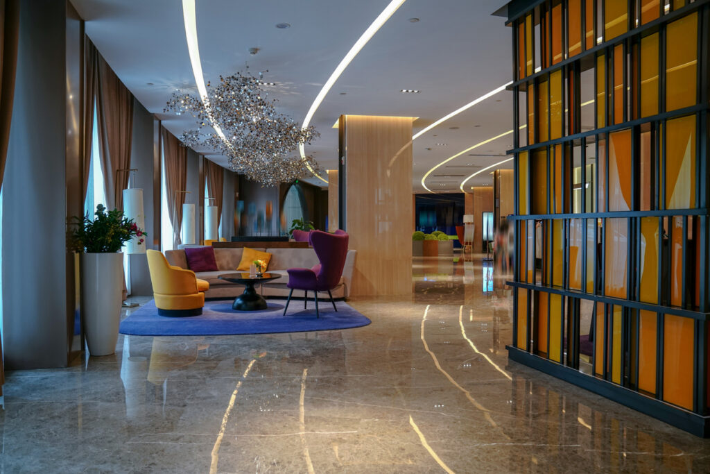 Luxury hotel lobby with modern LED lighting, colorful seating, and marble floors.