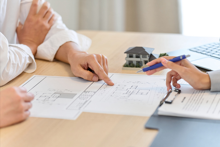 A man discussing floor plans with a client