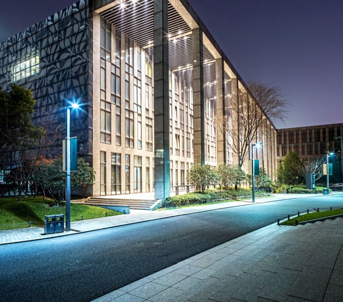 Modern office building illuminated by LED exterior lighting at night, showcasing architectural details and energy-efficient lighting solutions.